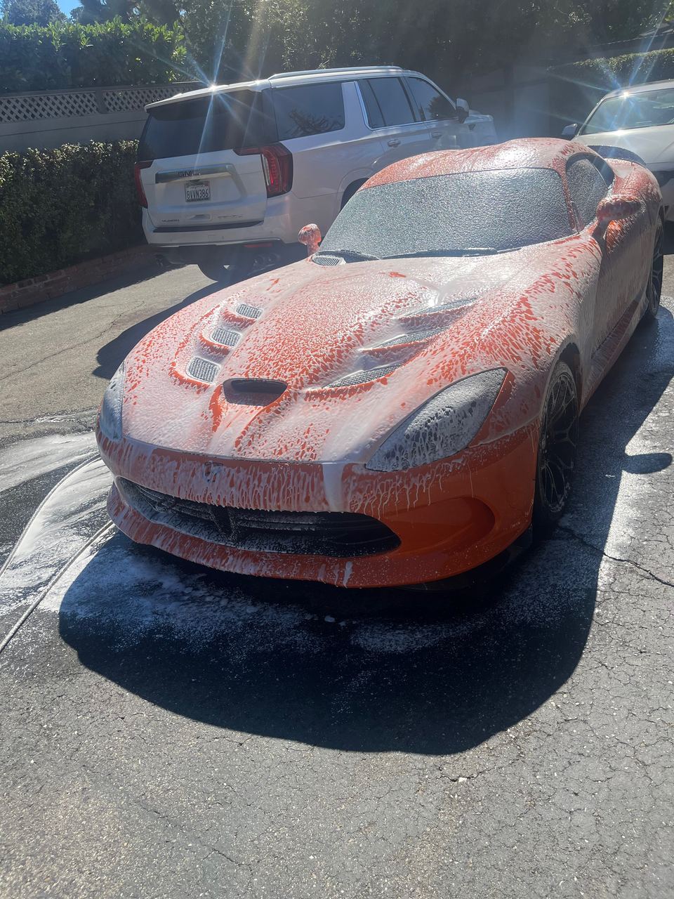 Orange Dodge Viper covered in wash foam
